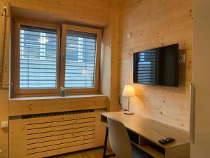 a room with a desk and a tv andwindows at W&G Hotel in Cologne