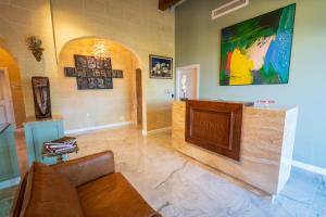 a living room with a couch and a large painting on the wall at L-Eremita Boutique Hotel in Qala