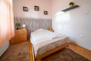 um pequeno quarto com uma cama e uma cómoda em Tomka Apartman em Szeged