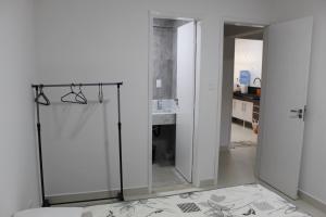 ein Bad mit einer Glasdusche und einem Spiegel in der Unterkunft Apt novissimo 3 quartos c elevador a 300m da orla Praia do Morro in Guarapari