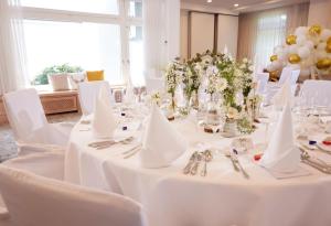 a dining room with white tables and white chairs at Hotel Derichsweiler Hof in Nümbrecht