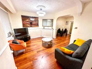 a living room with a couch and a television at Fortune 24 house in Rainham