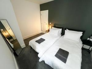 にあるStunning City Apartment - Parkingのベッドルーム1室(白いシーツと枕のベッド2台付)
