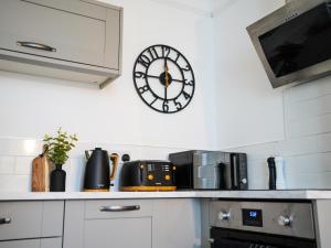 a clock on the wall above a kitchen counter at Stunning City Apartment - Parking 