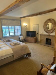 a bedroom with a bed and a tv and a fireplace at White Hall Farm in Leamington Spa