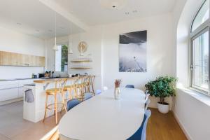 a kitchen and dining room with a white table and chairs at Villa de charme moderne avec piscine et vue mer in Nice
