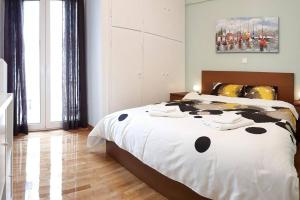 a bedroom with a bed with a black and white comforter at Cozy apartment close to Acropolis in Athens
