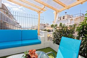 a blue bench on a balcony with a table and chairs at Cozy apartment close to Acropolis in Athens