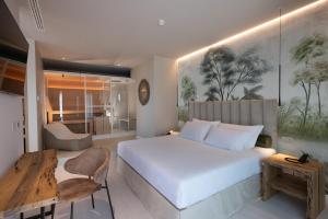 una camera con un grande letto bianco e una scrivania di Savoy Beach Hotel & Thermal Spa a Bibione