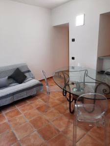 sala de estar con mesa de cristal y sofá en Le Coccinelle Home, en Mandello del Lario