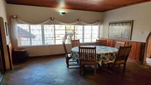 uma sala de jantar com uma mesa e cadeiras e uma janela em Bird's Nest Guest House em Keetmanshoop