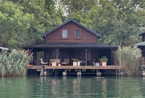 a house on a dock on a body of water at NuA House "Kapri" in Gornji Štoj