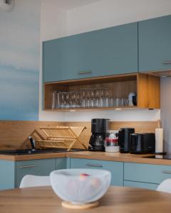 eine Küche mit blauen Schränken und einem Holztisch in der Unterkunft Gîte Estuaire du Trieux in Lézardrieux