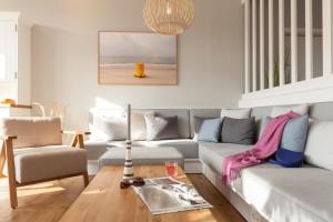 Wyn. Strandhotel Sylt في فيسترلاند: غرفة معيشة مع أريكة وطاولة