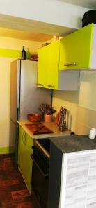 eine Küche mit hellgrünen Schränken und einem Kühlschrank in der Unterkunft Lilleheim in Mostar