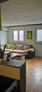 ein Wohnzimmer mit einem Sofa und einem Tisch in der Unterkunft Lilleheim in Mostar