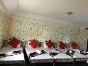2 Betten in einem Zimmer mit grünen und roten Kissen in der Unterkunft Vi-Da Guest Resort in Irosin