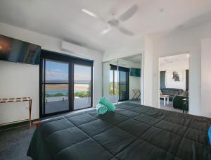 a bedroom with a large bed with a view of the ocean at Sunset Beach House 1770 in Seventeen Seventy