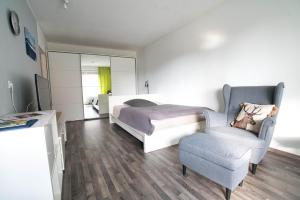 um quarto com uma cama e uma cadeira em Gaishöll-Wasserfälle Apartment Schwarzwald em Sasbachwalden