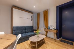 ein Wohnzimmer mit einem blauen Sofa und einem Tisch in der Unterkunft Gîte Estuaire du Trieux in Lézardrieux
