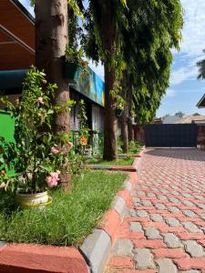 a brick walkway with trees in front of a building at Kilimanjaro Trekcity Hostel in Moshi