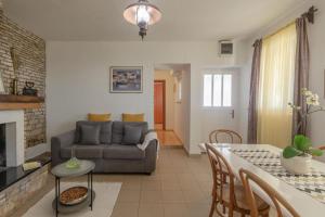 ein Wohnzimmer mit einem Sofa und einem Tisch in der Unterkunft Sea View House Sanja With Terrace - Happy Rentals in Vela Luka