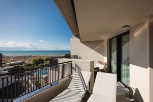 a balcony with chairs and a view of the beach at Savoy Beach Hotel & Thermal Spa in Bibione