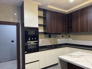 アブジャにあるJazeera Apartmentsのキッチン(白いキャビネット、黒の電化製品付)