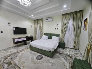 アブジャにあるJazeera Apartmentsのベッドルーム(ベッド1台、薄型テレビ付)
