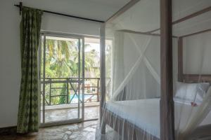 a bedroom with a bed and a large window at Villa Black Pearl - new private Villa in Diani Beach