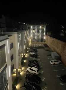 Una fila de autos estacionados en un estacionamiento por la noche en Garden apartment Brno center, en Brno