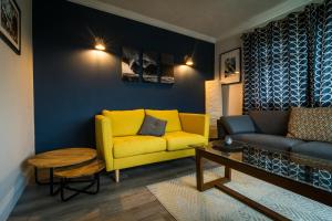 a living room with a yellow couch and a table at Port Aran House in Kilronan