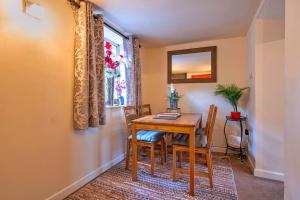 a dining room with a table and chairs and a window at Finest Retreats - Stonelea in Tideswell
