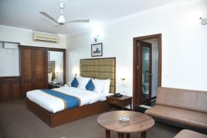 a hotel room with a bed and a couch at BelAir Suites Pune in Pune