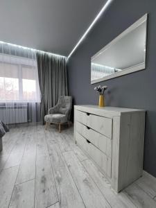 Habitación con tocador, espejo y silla. en Квартира - студия 72 кв.м, en Uralsk
