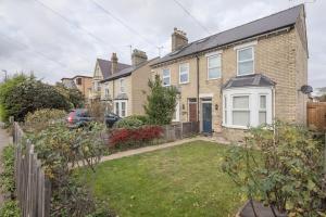 a brick house with a driveway and a yard at Superb Central 2 Bed Home in Cherry Hinton
