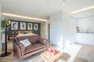 a living room with a couch and a bedroom at Luxury Central Riverside Apartment in Cambridge