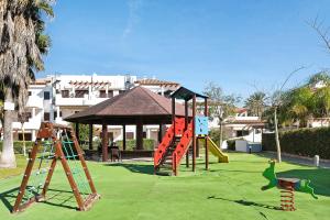 um parque com um parque infantil com escorregas e um gazebo em Atico Coto de Santi Petri 122 em Chiclana de la Frontera