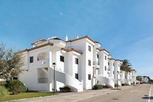 um edifício branco com varandas numa rua em Atico Coto de Santi Petri 122 em Chiclana de la Frontera