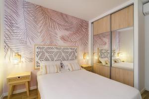 um quarto com uma cama branca e um mural de parede em Magnifique pavillon indépendant T2 Nice em Nice