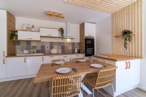 uma cozinha com uma mesa de madeira e cadeiras em Magnifique pavillon indépendant T2 Nice em Nice