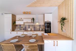 uma cozinha com uma mesa de madeira e cadeiras em Magnifique pavillon indépendant T2 Nice em Nice