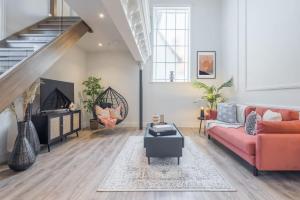 a living room with a red couch and a staircase at Deluxe Modern-themed 1 Bedroom Apartment in Cambridge