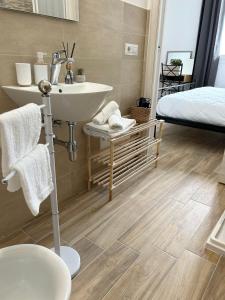 een badkamer met een wastafel en een bed bij Marina Casa Vacanza in Capoterra