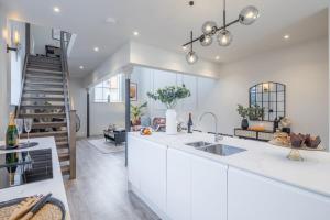 a kitchen with white cabinets and a staircase at Deluxe Modern-themed 1 Bedroom Apartment in Cambridge