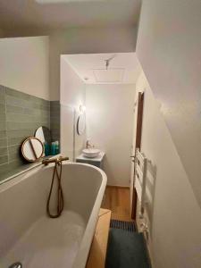 ein Badezimmer mit einer Badewanne und einem Waschbecken in der Unterkunft Charmante chambre avec sa salle de bain, vue mer. in Le Conquet