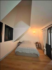 ein Schlafzimmer mit einem Bett im Dachgeschoss in der Unterkunft Charmante chambre avec sa salle de bain, vue mer. in Le Conquet