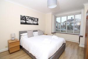 a bedroom with a white bed and a large window at VERY SPACIOUS House For 6 In Fantastic Location in Cambridge