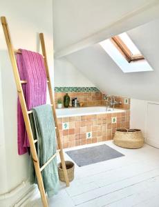een badkamer met een handdoekradder en een bad bij Maison familiale avec vue Tour Eiffel in Suresnes