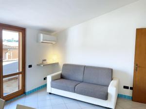 un divano in una stanza con finestra di Attico Ta Rosalba a Porto Azzurro